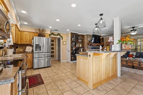 a kitchen with stainless steel appliances kitchen island granite countertop a refrigerator and a stove