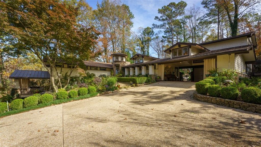 a front view of a house with a yard and potted plants