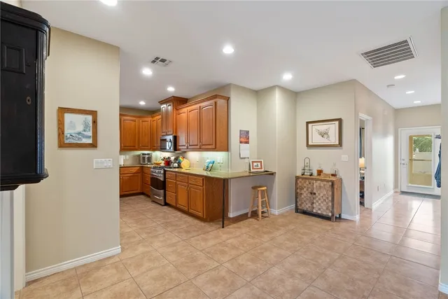 a large kitchen with a large counter top and stainless steel appliances