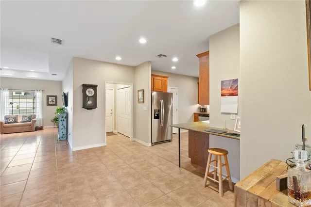 a open kitchen with stainless steel appliances kitchen island granite countertop a refrigerator and a sink