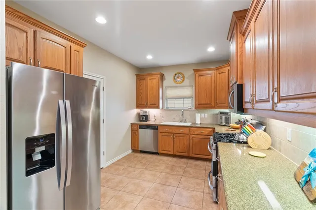 a kitchen with stainless steel appliances granite countertop a refrigerator a sink a stove with island