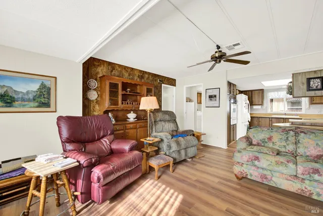 a dining room with furniture a chandelier and wooden floor