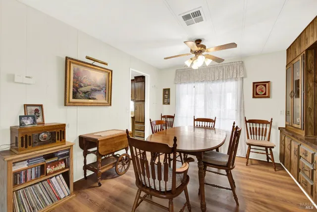 a view of a hallway with wooden floor and a bathroom