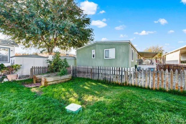a view of an house with backyard and a tree