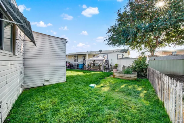a view of a house with backyard and sitting area