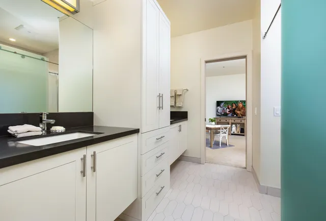 a spacious bathroom with a granite countertop sink and a mirror