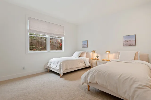 a bedroom with two beds and a window