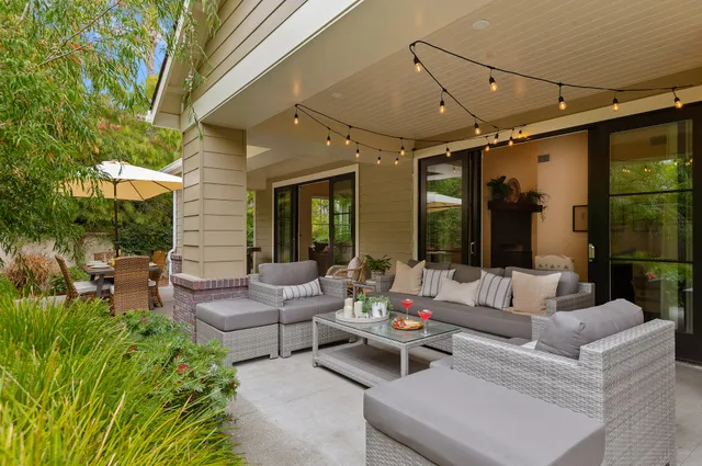 a outdoor space with patio the couches and a dining table with large tree