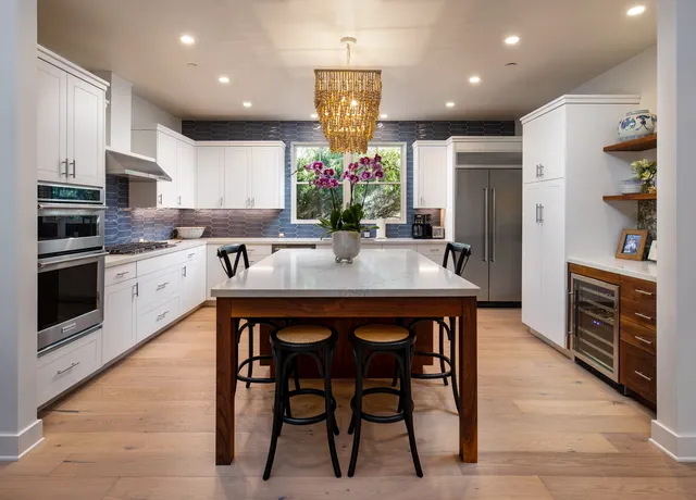 a kitchen with stainless steel appliances granite countertop a stove refrigerator and cabinets