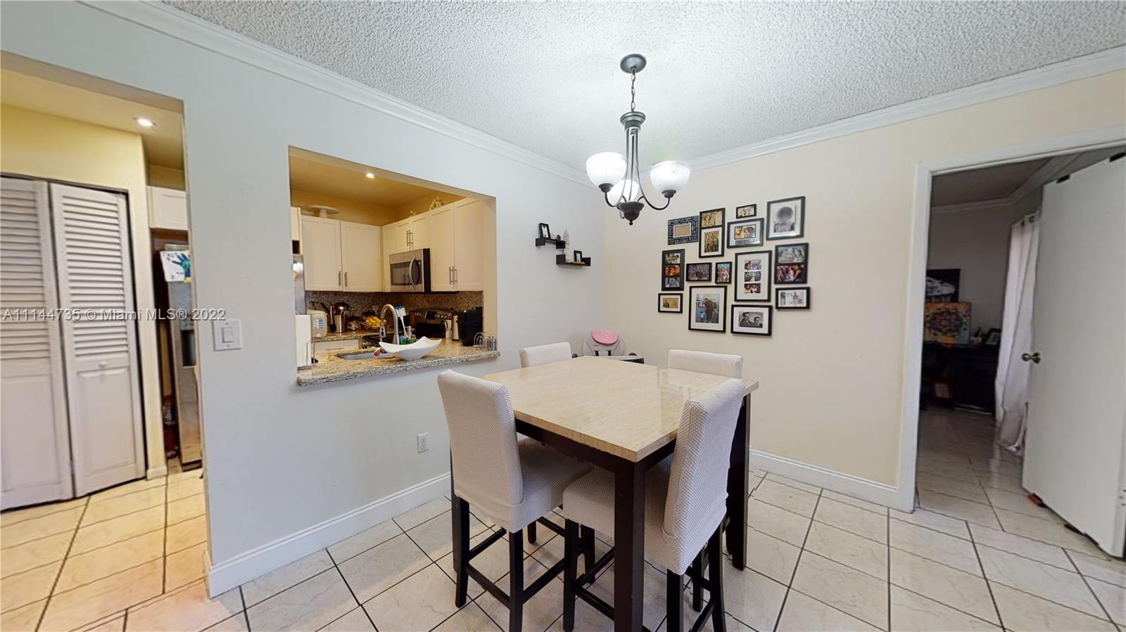 14911 Southwest 104th Street, Unit 1722 Miami, FL 33196 - Photo 11 of 29 a kitchen with a table and refrigerator