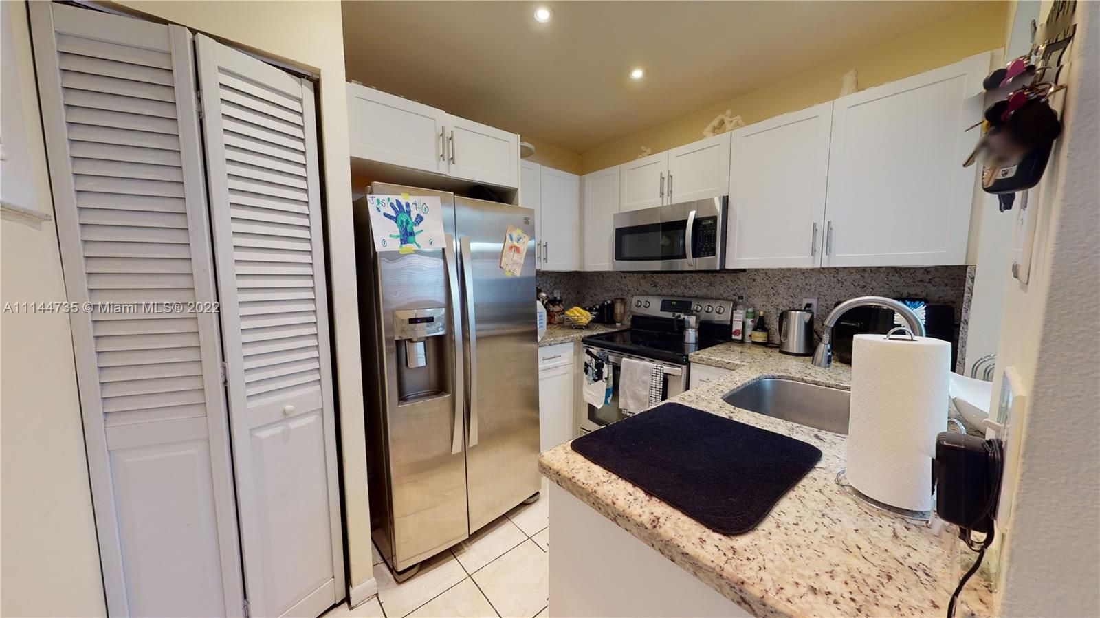 14911 Southwest 104th Street, Unit 1722 Miami, FL 33196 - Photo 13 of 29 a kitchen with stainless steel appliances granite countertop a refrigerator and a stove top oven
