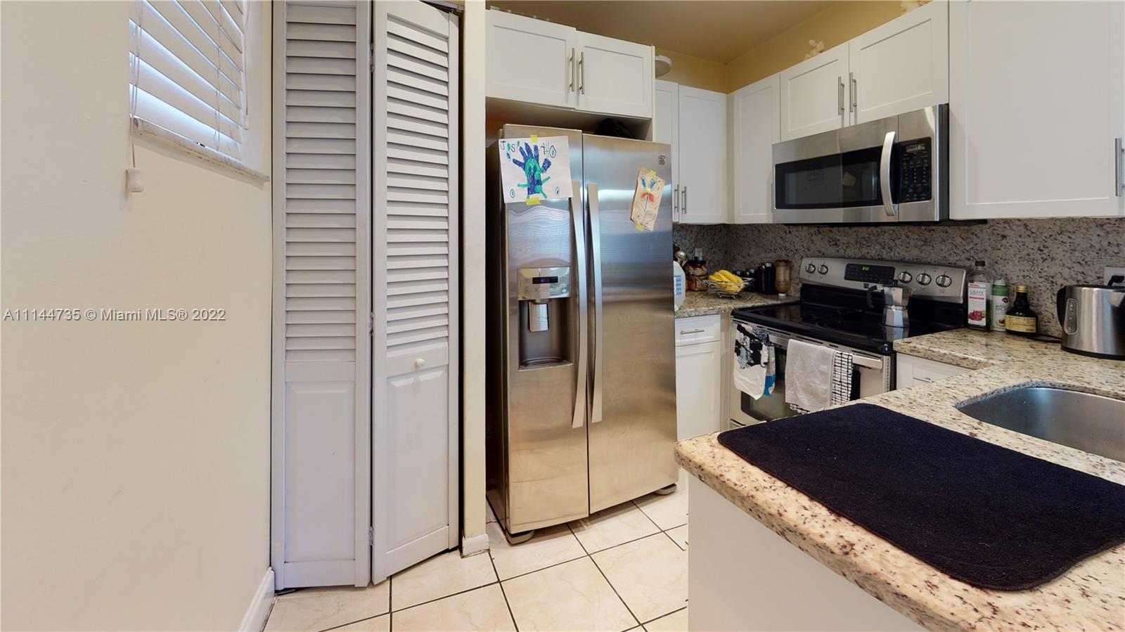 14911 Southwest 104th Street, Unit 1722 Miami, FL 33196 - Photo 14 of 29 a kitchen with stainless steel appliances granite countertop a refrigerator a stove and a sink with wooden floor