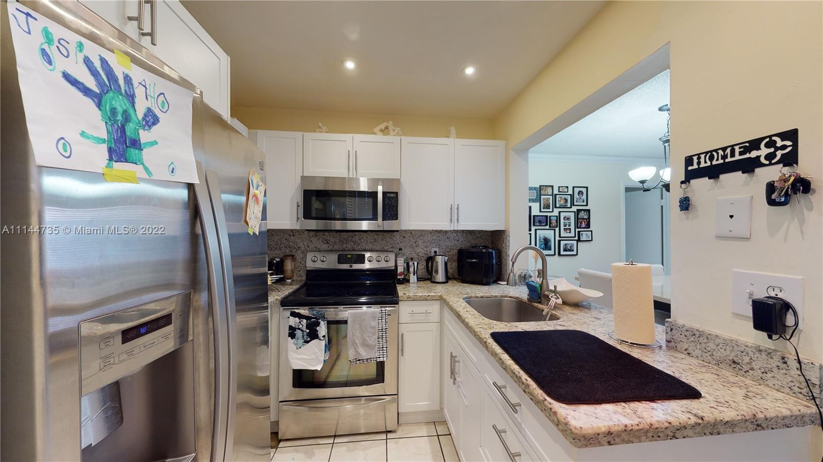 14911 Southwest 104th Street, Unit 1722 Miami, FL 33196 - Photo 16 of 29 a kitchen with stainless steel appliances granite countertop a refrigerator and a stove top oven