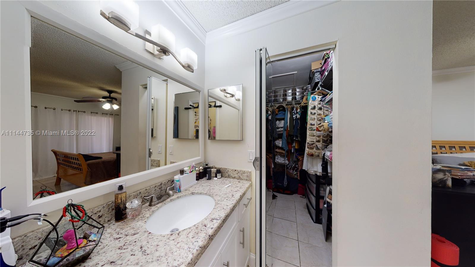 14911 Southwest 104th Street, Unit 1722 Miami, FL 33196 - Photo 24 of 29 a bathroom with a granite countertop sink a mirror and shower