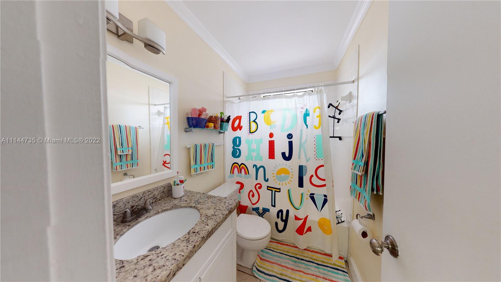 14911 Southwest 104th Street, Unit 1722 Miami, FL 33196 - Photo 28 of 29 a bathroom with a granite countertop sink and a shower curtain
