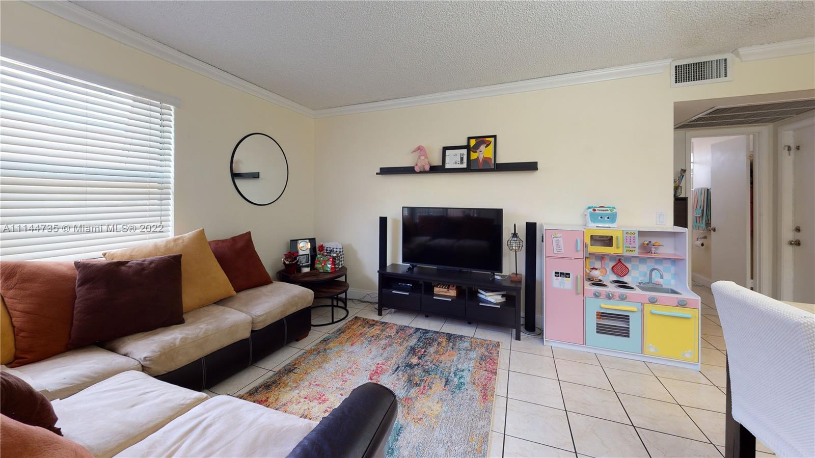 14911 Southwest 104th Street, Unit 1722 Miami, FL 33196 - Photo 7 of 29 a living room with furniture and a flat screen tv