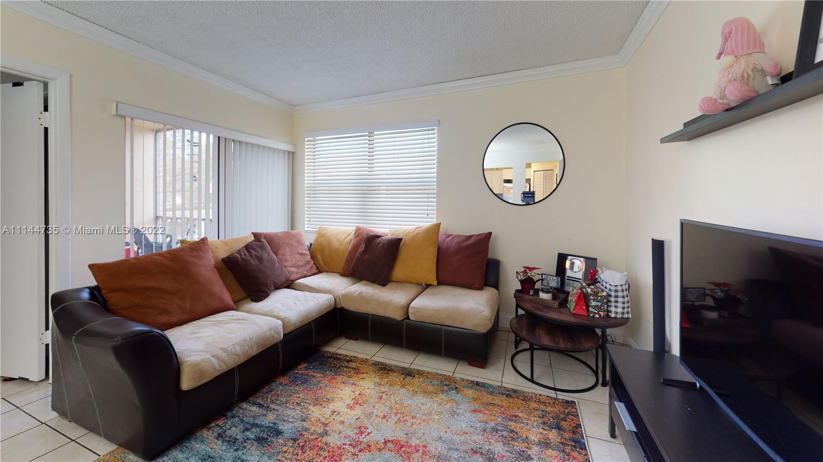 14911 Southwest 104th Street, Unit 1722 Miami, FL 33196 - Photo 8 of 29 a living room with furniture a flat screen tv and a window