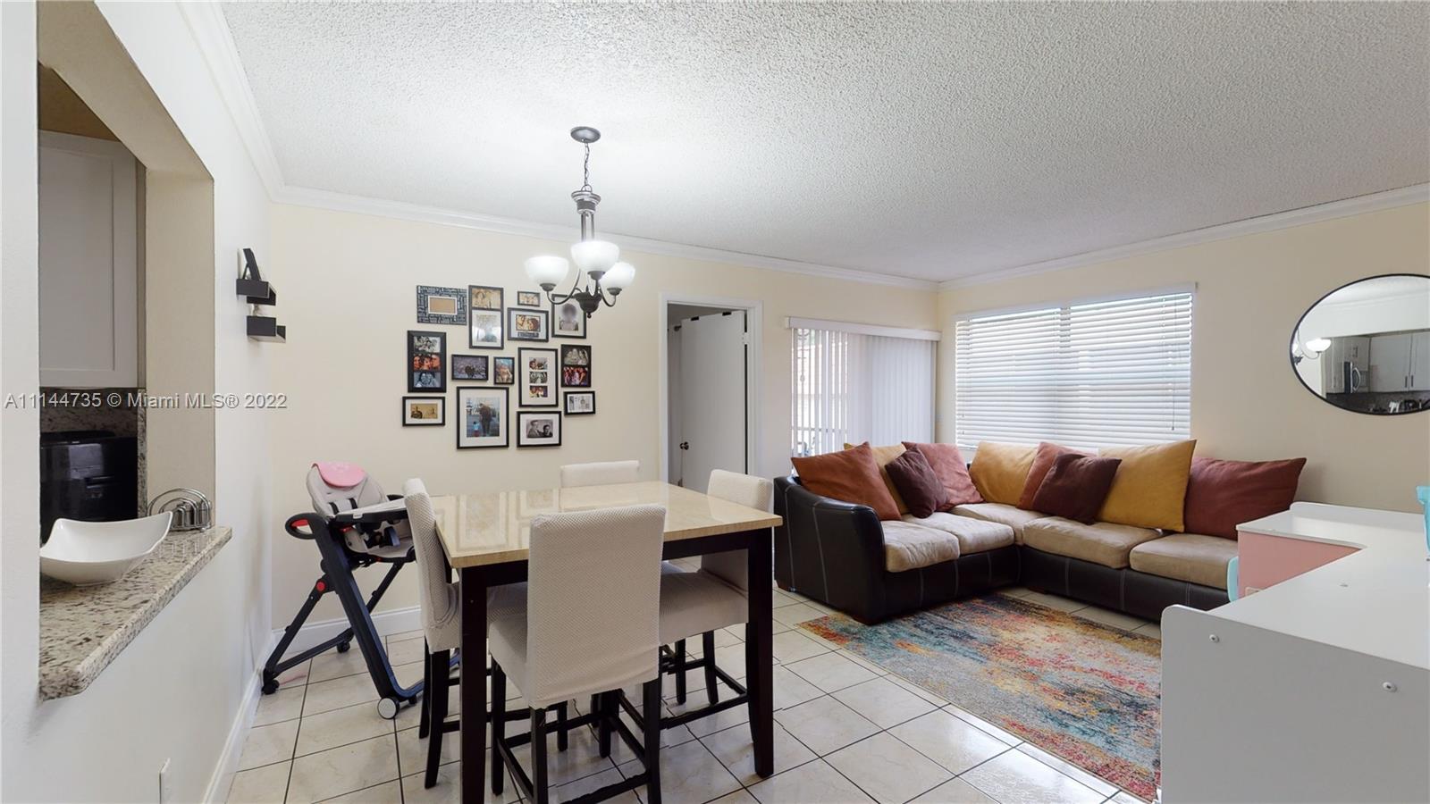 14911 Southwest 104th Street, Unit 1722 Miami, FL 33196 - Photo 9 of 29 a living room with furniture and a chandelier