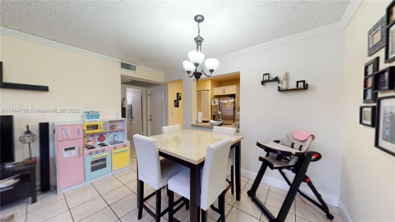 14911 Southwest 104th Street, Unit 1722 Miami, FL 33196 - Photo 10 of 29 a view of a dining room with furniture and a chandelier
