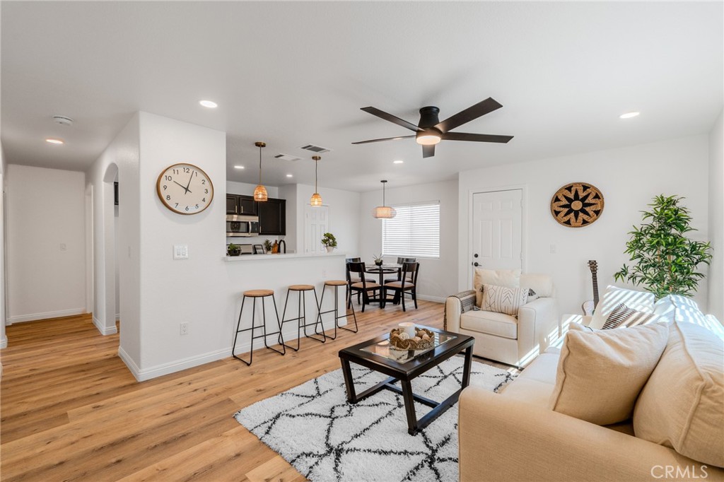 a living room with furniture a clock on wall and a window