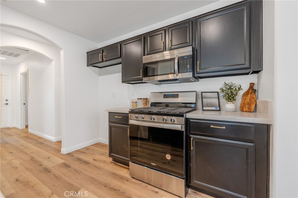 34634 Pso Del Valle Barstow, CA 92311 - Photo 6 of 37 a kitchen with stainless steel appliances a stove a microwave and cabinets