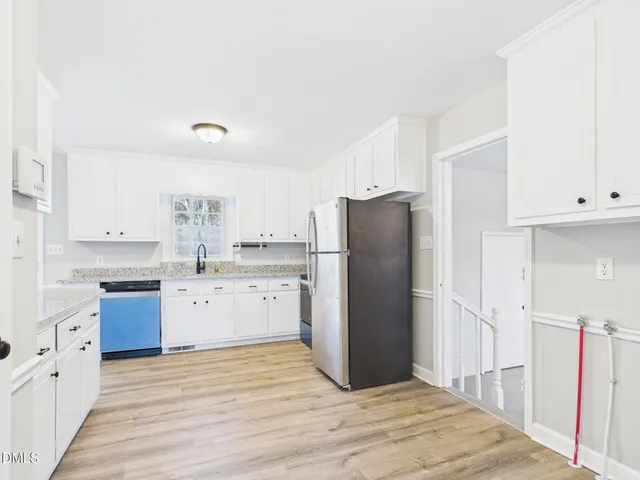 a kitchen with a refrigerator sink stove and cabinets