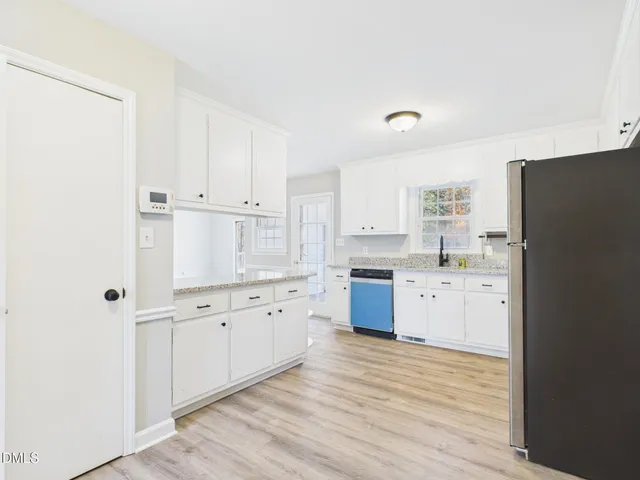 a kitchen with granite countertop white cabinets and white appliances