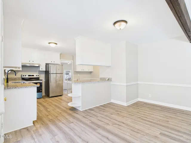 a kitchen with a refrigerator and a stove top oven