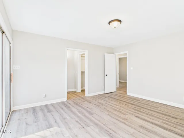 a view of an empty room with wooden floor