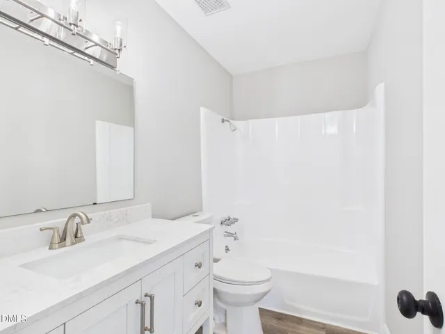 a bathroom with a granite countertop sink a toilet and a mirror