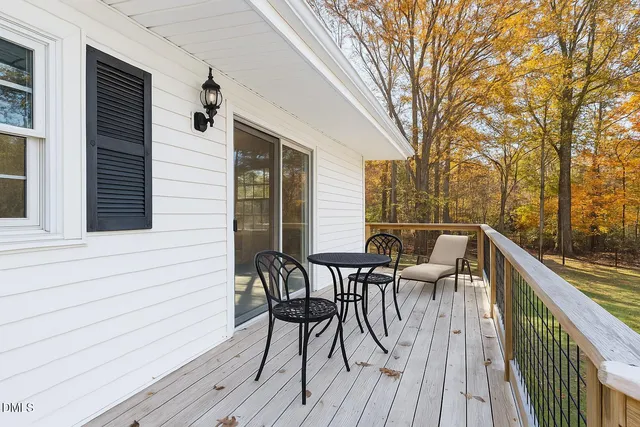 a view of a roof deck with table and chairs and wooden floor