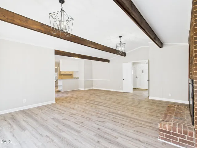 a view of empty room with wooden floor and windows