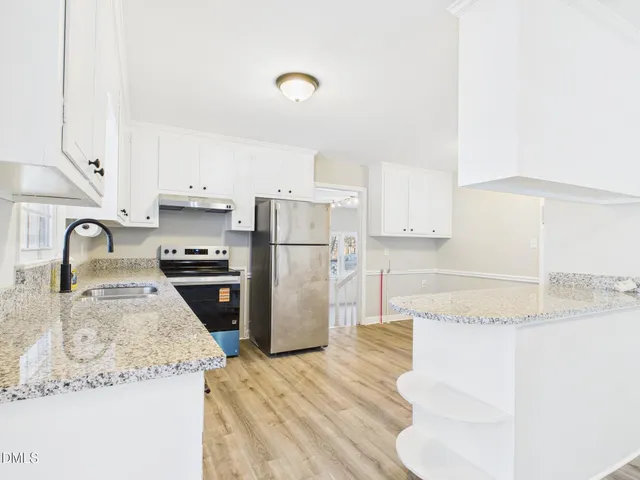 a kitchen with granite countertop a sink a refrigerator and a stove