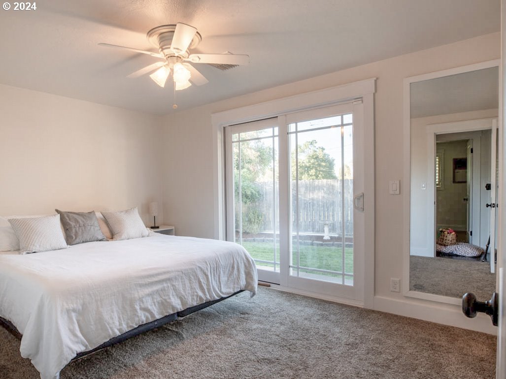 1440 Fetlock Court Eugene, OR 97401 - Photo 13 of 31 a bedroom with a large bed and a chandelier