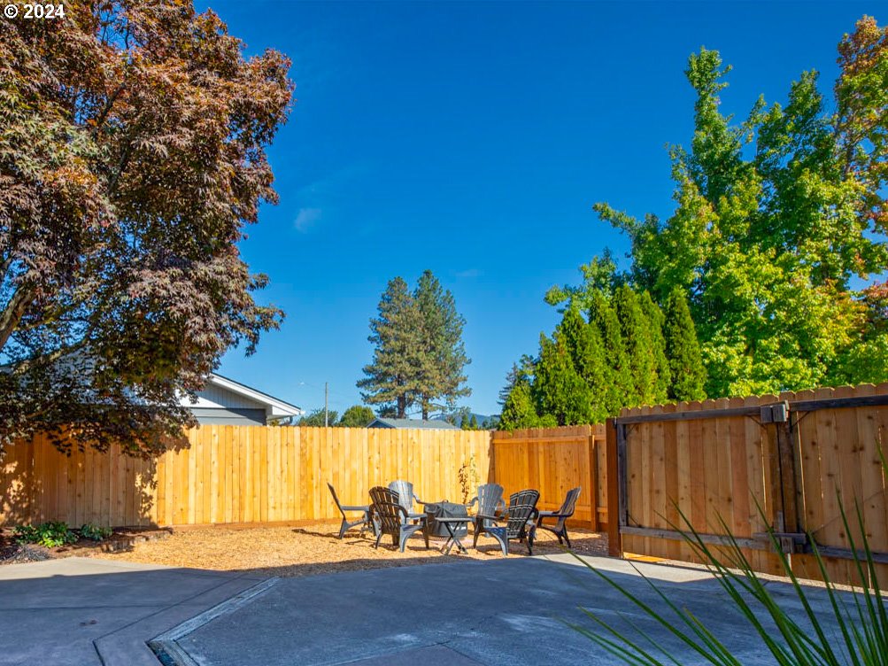 1440 Fetlock Court Eugene, OR 97401 - Photo 21 of 31 a view of a backyard with a large tree and wooden fence