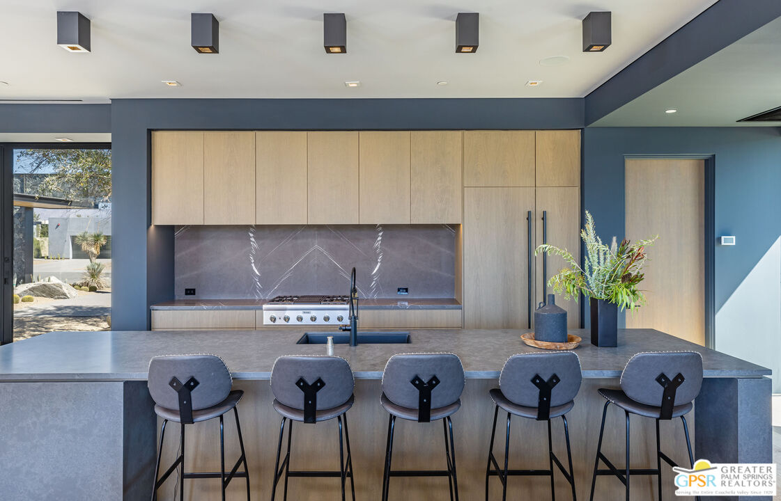 1 Echo Lane Rancho Mirage, CA 92270 - Photo 25 of 51 a kitchen with stainless steel appliances a sink a table and chairs in it