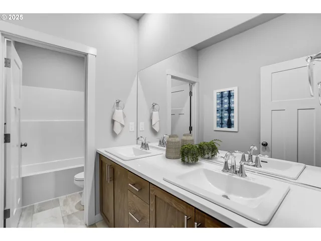 a bathroom with a sink double vanity granite tub shower and a mirror