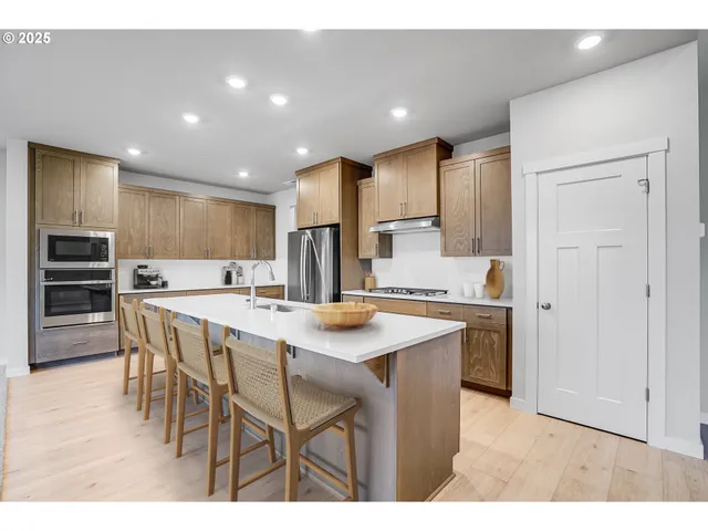 a kitchen with stainless steel appliances kitchen island granite countertop a sink and cabinets