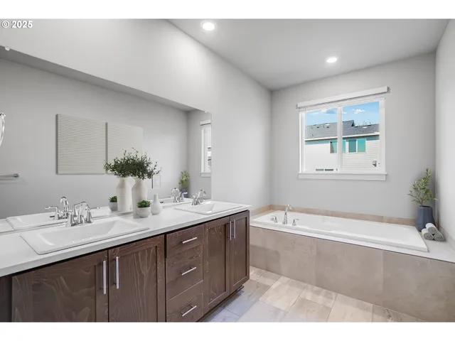 a bathroom with a tub a sink and mirror
