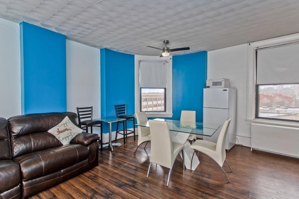 140 Chestnut Street, Unit 406 Springfield, MA 01103 - Photo 6 of 42 a living room with furniture a wooden floor and a window