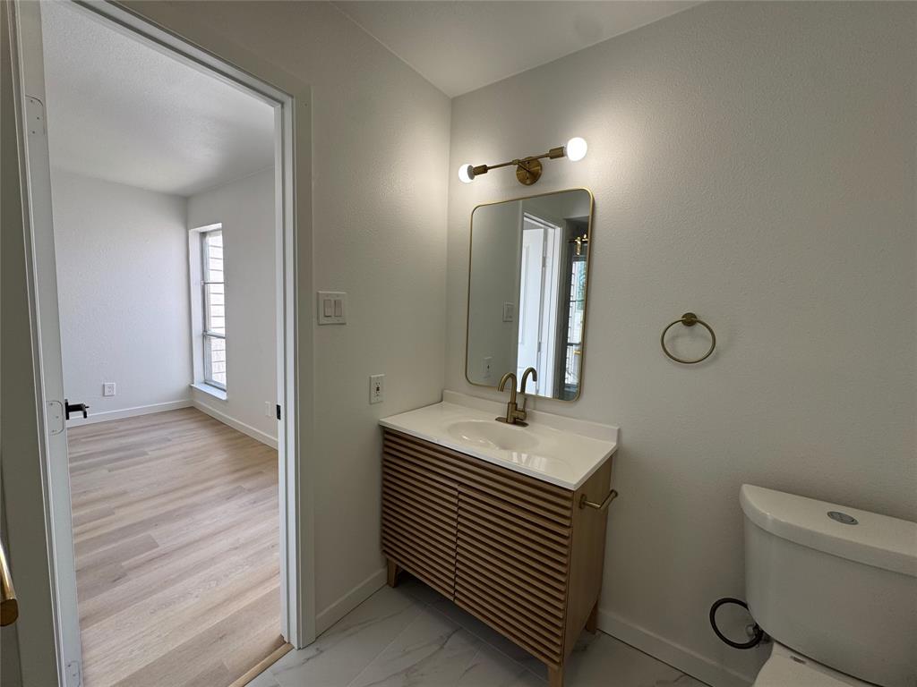 5510 Boca Raton Boulevard, Unit 431 Fort Worth, TX 76112 - Photo 17 of 19 a bathroom with a sink a toilet and mirror