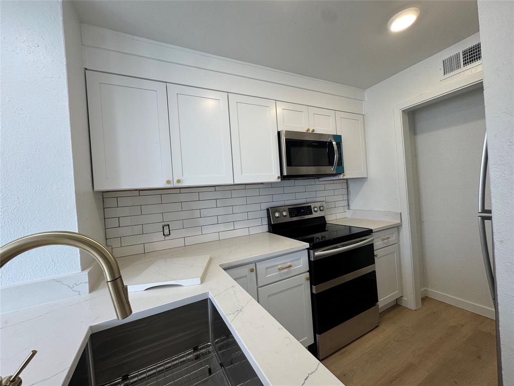 5510 Boca Raton Boulevard, Unit 431 Fort Worth, TX 76112 - Photo 6 of 19 a kitchen with a stove and a microwave