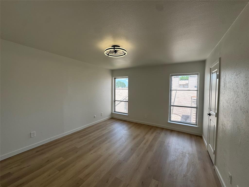 5510 Boca Raton Boulevard, Unit 431 Fort Worth, TX 76112 - Photo 10 of 19 an empty room with wooden floor closet and windows