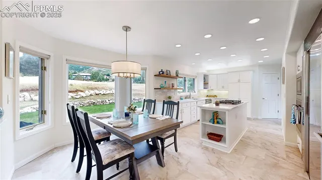 a dining room with furniture a chandelier and kitchen view