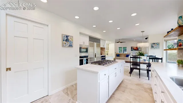 a kitchen with a sink a counter top space appliances and cabinets