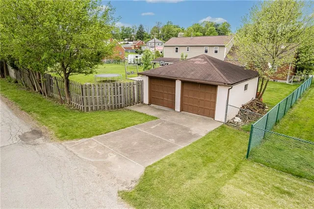 a view of a house with a yard and large tree