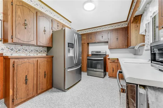 a kitchen with stainless steel appliances granite countertop a refrigerator and a stove