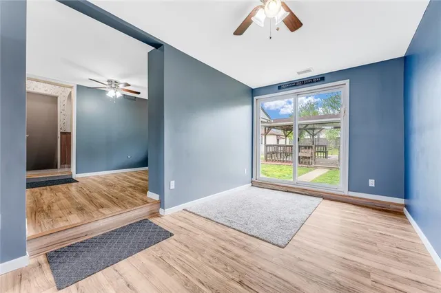 a view of hallway with a bed and wooden floor