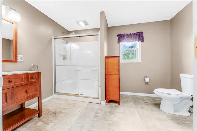 a bathroom with a toilet and a shower