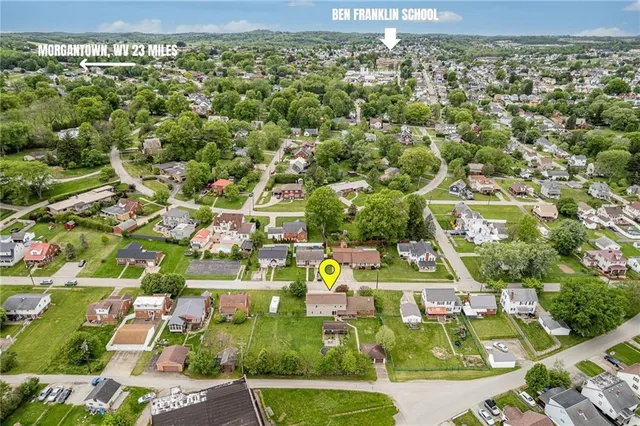 an aerial view of residential houses with outdoor space and trees